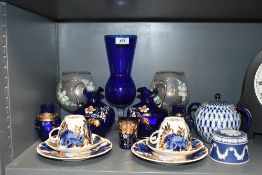 A collection of blue wares including a pair of cobalt blue glass pitchers decorated in hand