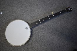 A vintage banjo having metal body with Remo skin and star and dot inlay to the neck with crescent