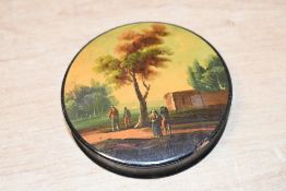 A small Georgian papier mâché round snuff/patch box, featuring a hand painted rural scene of figures