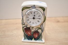 A small contemporary Moorcroft Pottery Trial mantel clock, featuring tube-lined pink and red lillies