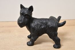 A vintage cast iron Scottish Terrier door stop, featuring a textured coat and cocked leg,