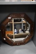 A early to mid 20th-century octagonal bevelled oak wall mirror, featuring hand carved beaded
