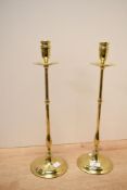 Two tall early 19th-century brass altar candlesticks, featuring urn-shaped sockets with slender