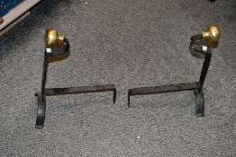 Two early 20th-century wrought iron andirons, featuring a polished brass ball finial on top,