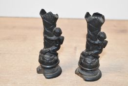 Two small 19th-century cast metal figural candlesticks, each featuring a putto-type figure upon a