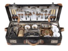 A LEATHER CASED PICNIC BASKET with fitted interior containing cutlery, plates, cups,