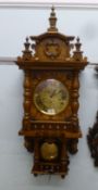 A modern beech and oak cased wall clock; the German movement faced by a Roman dial  39"h  16"w