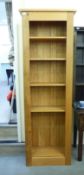 A modern light oak bookcase with one fixed and four height adjustable shelves, on a plinth  76"h