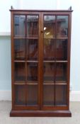 An early 20thC glazed front mahogany bookcase with a galleried top and three enclosed adjustable