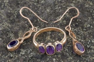A modern amethyst three-stone ring; and a pair of amethyst pendant earrings