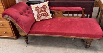 A Victorian chaise longue upholstered in red with a spindle back on turned legs and casters
