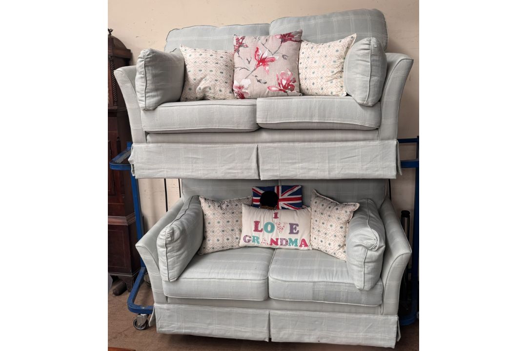 A pair of upholstered two seater settees in blue with a chequer pattern