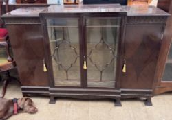 A 20th century mahogany display cabinet with a steeped top,