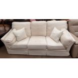 A cream upholstered three seater settee