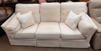 A cream upholstered three seater settee