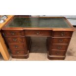 A Charles Barr reproduction pedestal desk with a leather inset inverted breakfront top above a