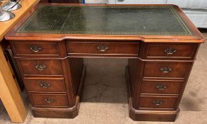 A Charles Barr reproduction pedestal desk with a leather inset inverted breakfront top above a