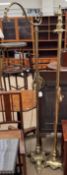 A pair of brass standard lamps with swan neck stems on cylindrical columns and trefoil bases with