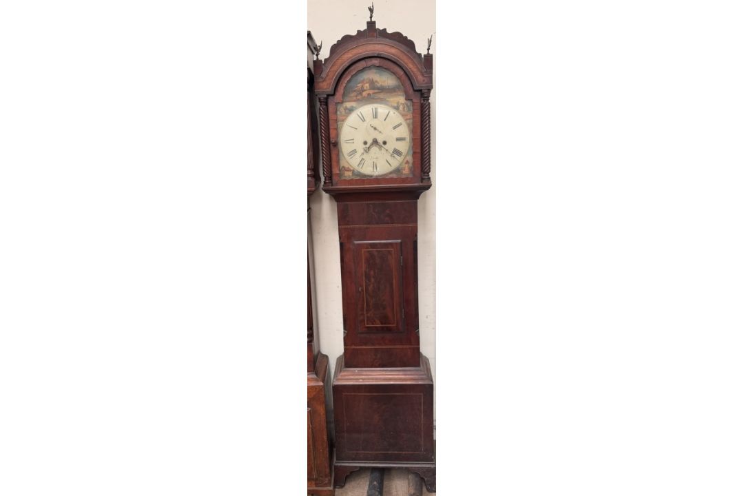 A 19th century mahogany longcase clock with an arched hood, short trunk door,