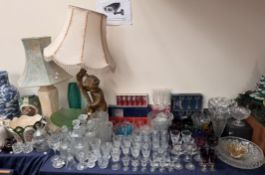 Coloured and faceted wine glasses together with a large quantity of glasswares, table lamps,