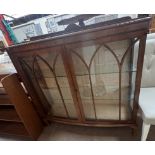 A 20th century walnut display cabinet with a D shaped top and a pair of door with glazed sides on