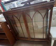 A 20th century walnut display cabinet with a D shaped top and a pair of door with glazed sides on