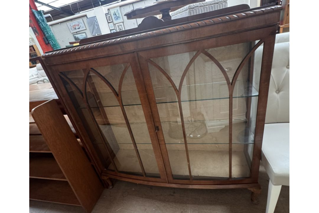 A 20th century walnut display cabinet with a D shaped top and a pair of door with glazed sides on