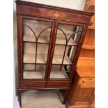 An Edwardian mahogany display cabinet with a moulded cornice above a vase decorated frieze,