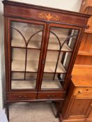 An Edwardian mahogany display cabinet with a moulded cornice above a vase decorated frieze,