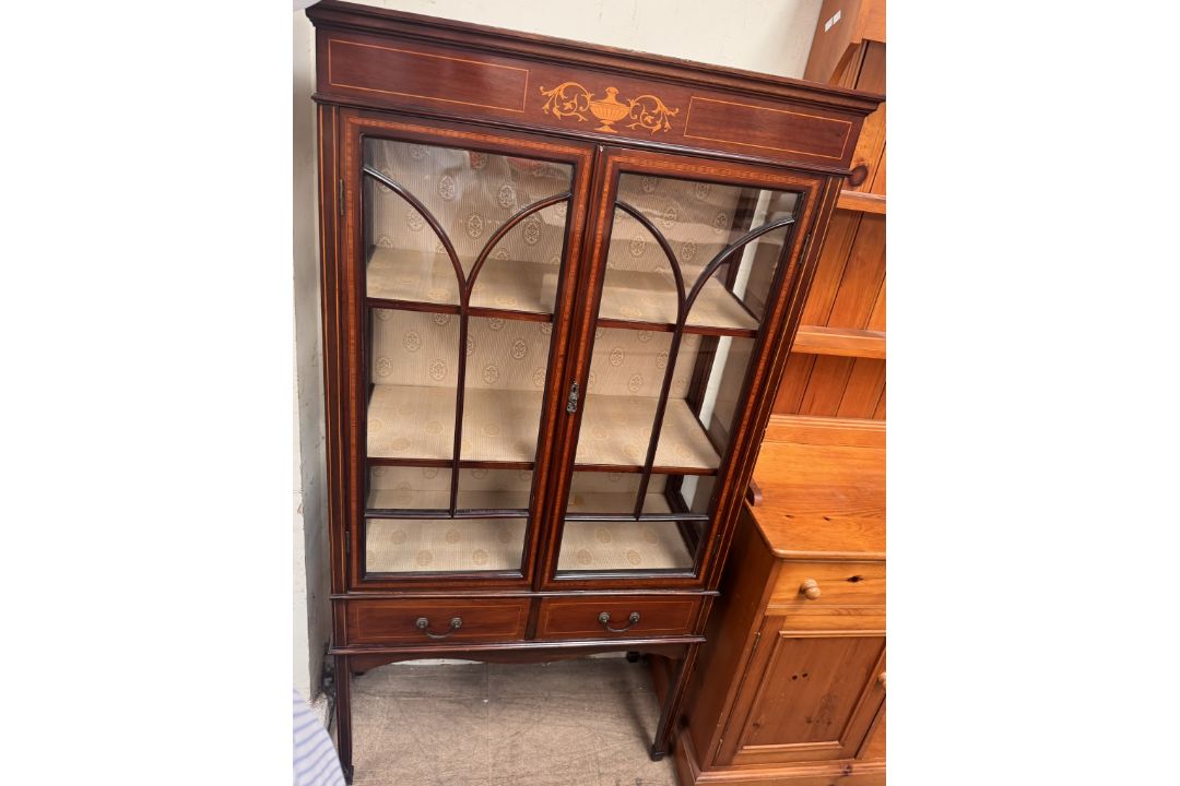 An Edwardian mahogany display cabinet with a moulded cornice above a vase decorated frieze,