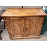 A pine side cabinet with a rectangular top above a pair of cupboard doors on square feet, 84.