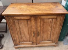 A pine side cabinet with a rectangular top above a pair of cupboard doors on square feet, 84.