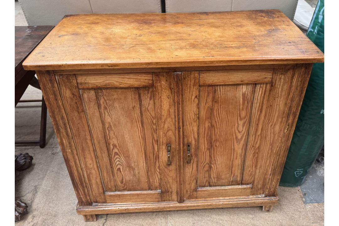 A pine side cabinet with a rectangular top above a pair of cupboard doors on square feet, 84.