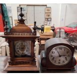 A walnut mantle clock with a domed top and finials above a silvered dial and Arabic numerals