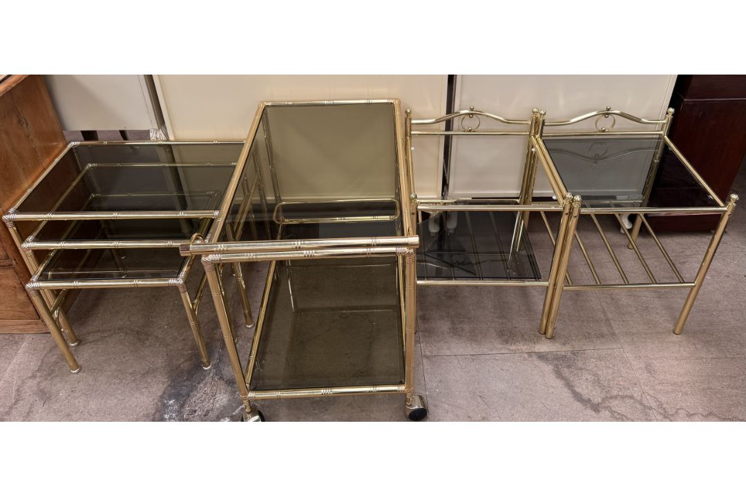 A brass framed and smoked glass tea trolley together with a similar nest of three tables and two