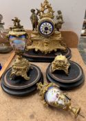 A clock garniture comprising a gilt metal and porcelain clock with Roman numerals and a pair of