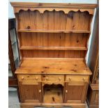 A pine dresser with a moulded cornice above two shelves, the base with three drawers,