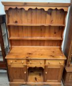 A pine dresser with a moulded cornice above two shelves, the base with three drawers,