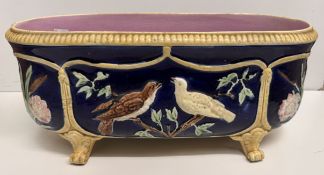 A Majolica jardiniere of oval form decorated with birds on scrolling feet