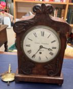 A 19th century mahogany bracket clock with a carved cresting rail,