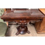 A Victorian rosewood card table with a foldover top lacking baize on a pedestal column,