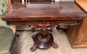 A Victorian rosewood card table with a foldover top lacking baize on a pedestal column,