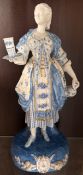A Paul Duboy porcelain model of a maiden holding a vase and cups and saucers, signed to the reverse,