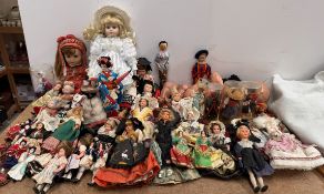 A collection of souvenir dolls and a large doll