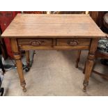 A 19th century pine side table with a rectangular top above a pair of drawers on turned legs