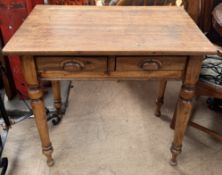A 19th century pine side table with a rectangular top above a pair of drawers on turned legs