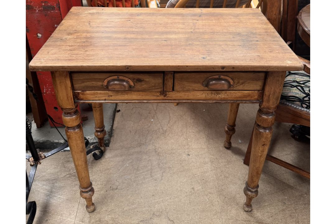 A 19th century pine side table with a rectangular top above a pair of drawers on turned legs