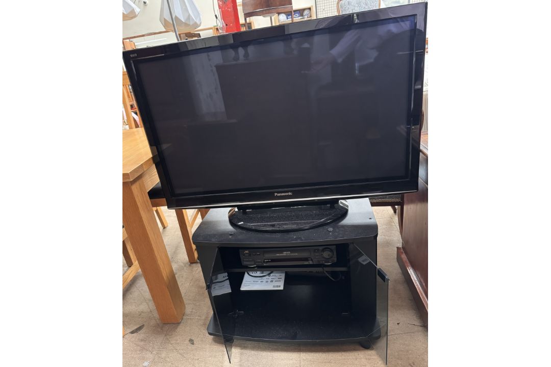A Panasonic 42" television together with a JVC video recorder and a television stand