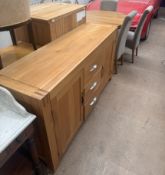 A modern oak dining suite comprising a circular table, five chairs,