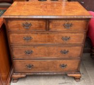 A reproduction walnut chest with a rectangular crossbanded and herringbone strung top above two